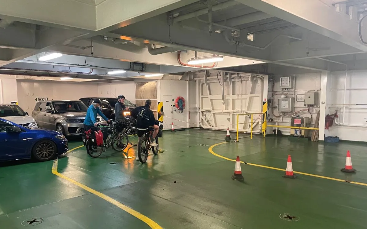 Cyclistes et vélos chargés de sacoches sur le pont véhicules d’un ferry